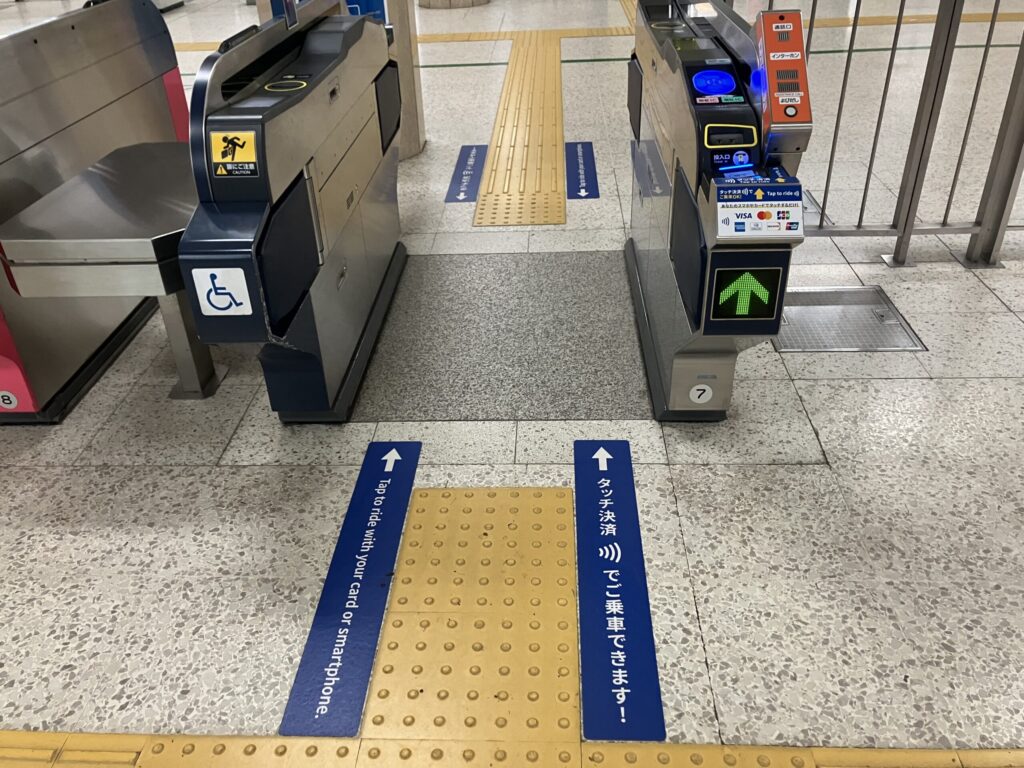 Not every subway gate supports contactless payment yet, so look for gates with the credit card/tap payment signs like this.